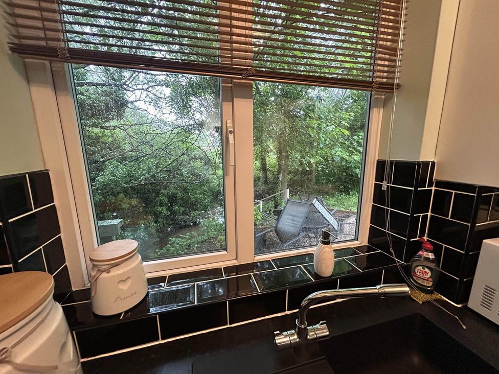 A view from a kitchen window showing a garden and a sink at a property