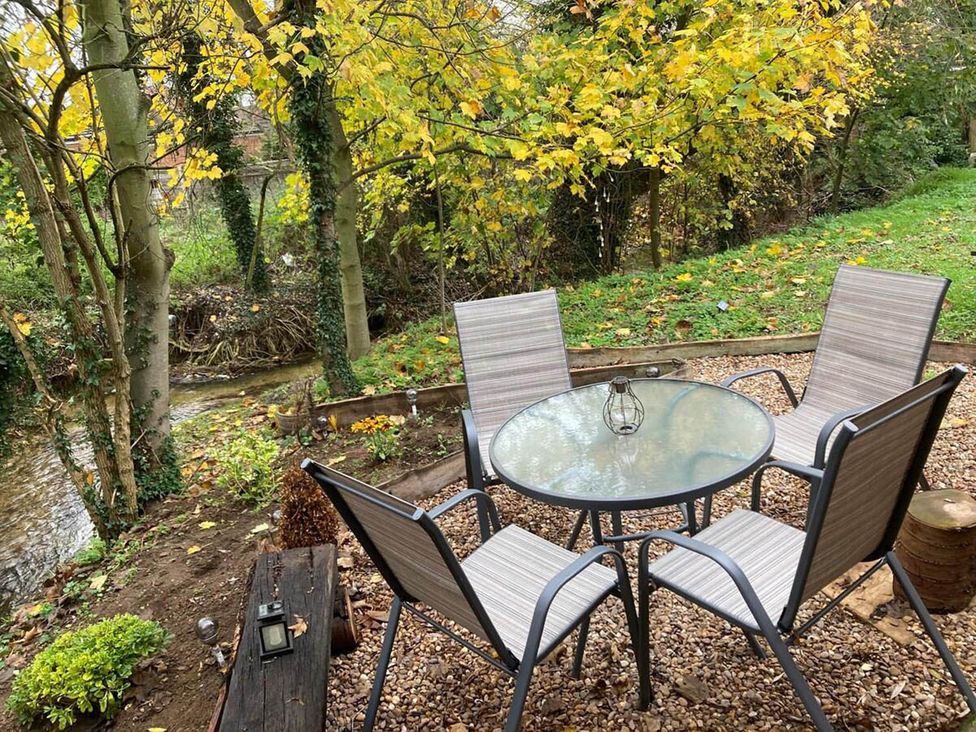 An outdoor seating area with a table and chairs by a stream
