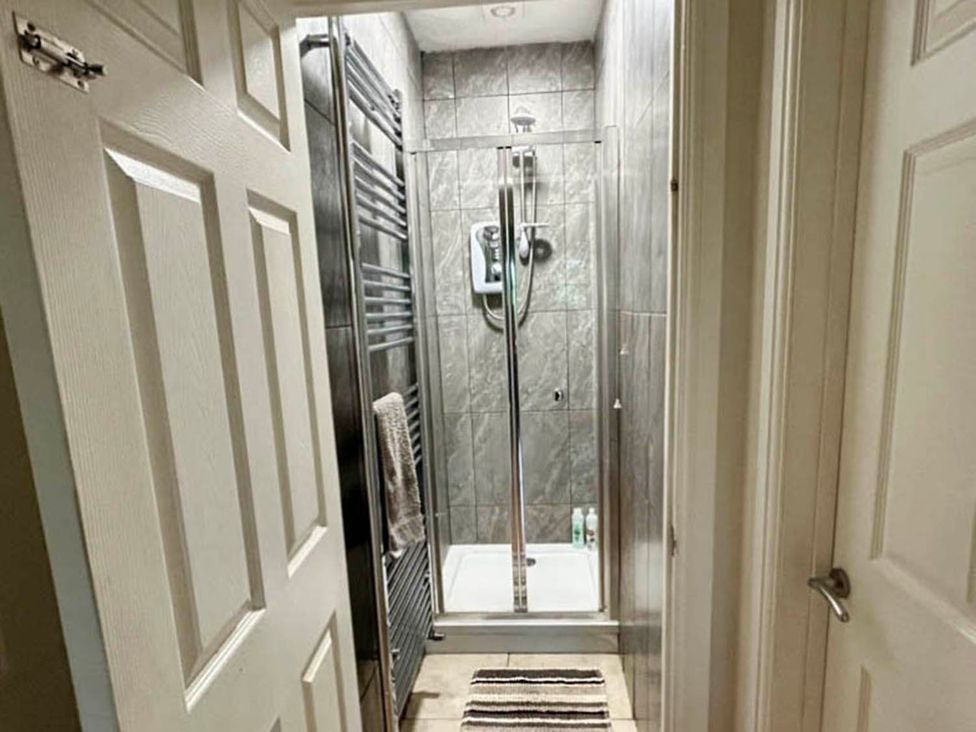 A shower area with a towel rack and door at the property
