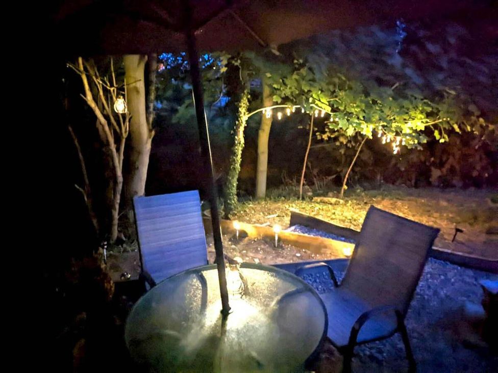 A table with chairs and lights at a garden patio
