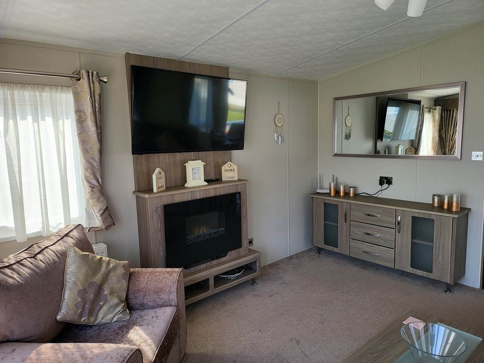 A living room with a television and fireplace at a property
