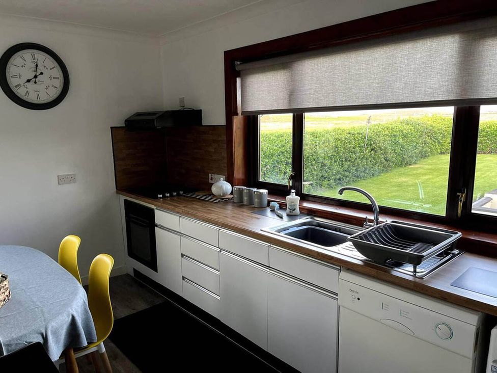 A kitchen with sink and clock at the property in unknown location