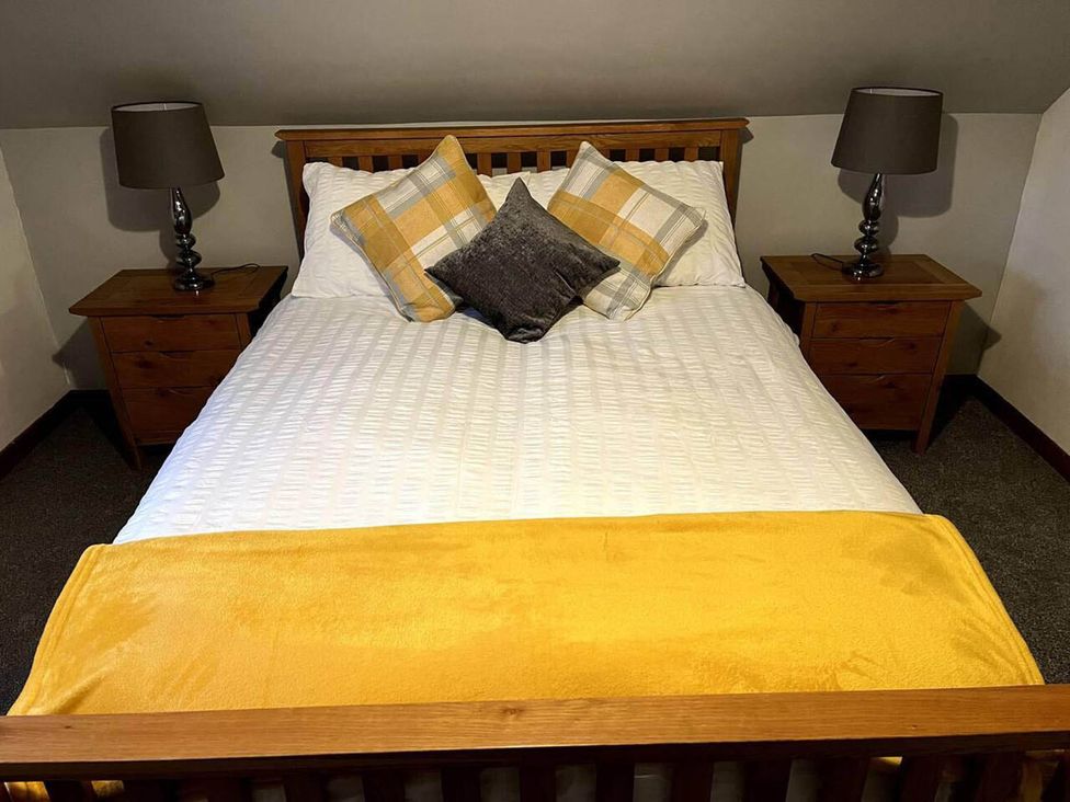 A bedroom with a bed and bedside tables at 