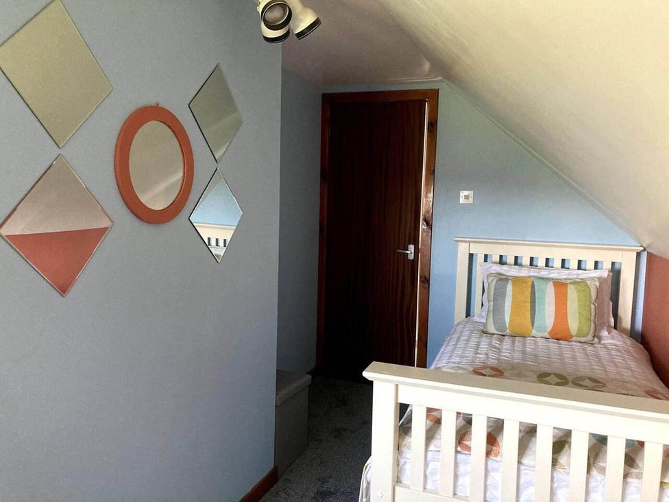 A bedroom with a single bed and decorative mirrors at The Old Barn in Manchester