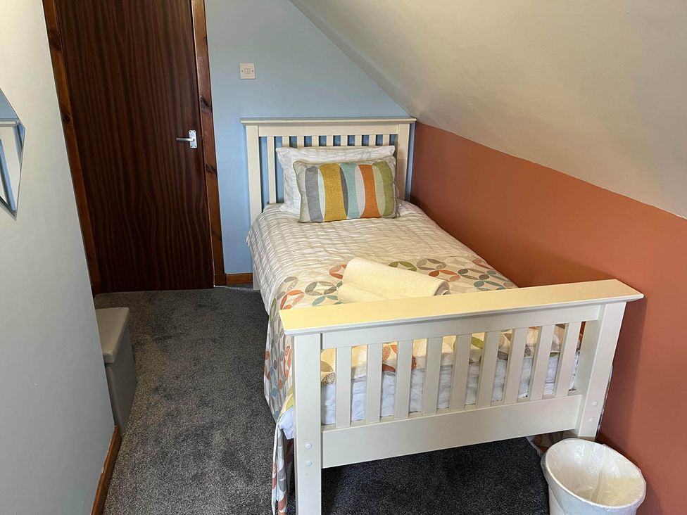 A bedroom with a single bed and a wastebasket at the property in 
