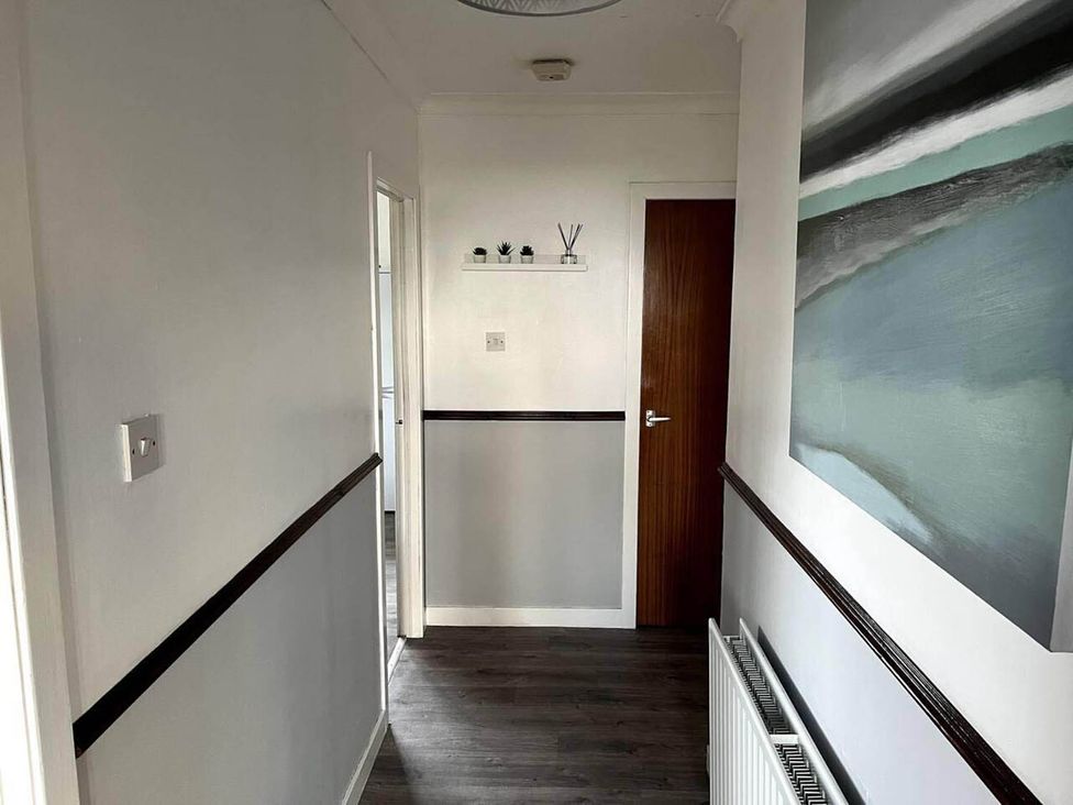 A hallway with a shelf and painting at the property in 