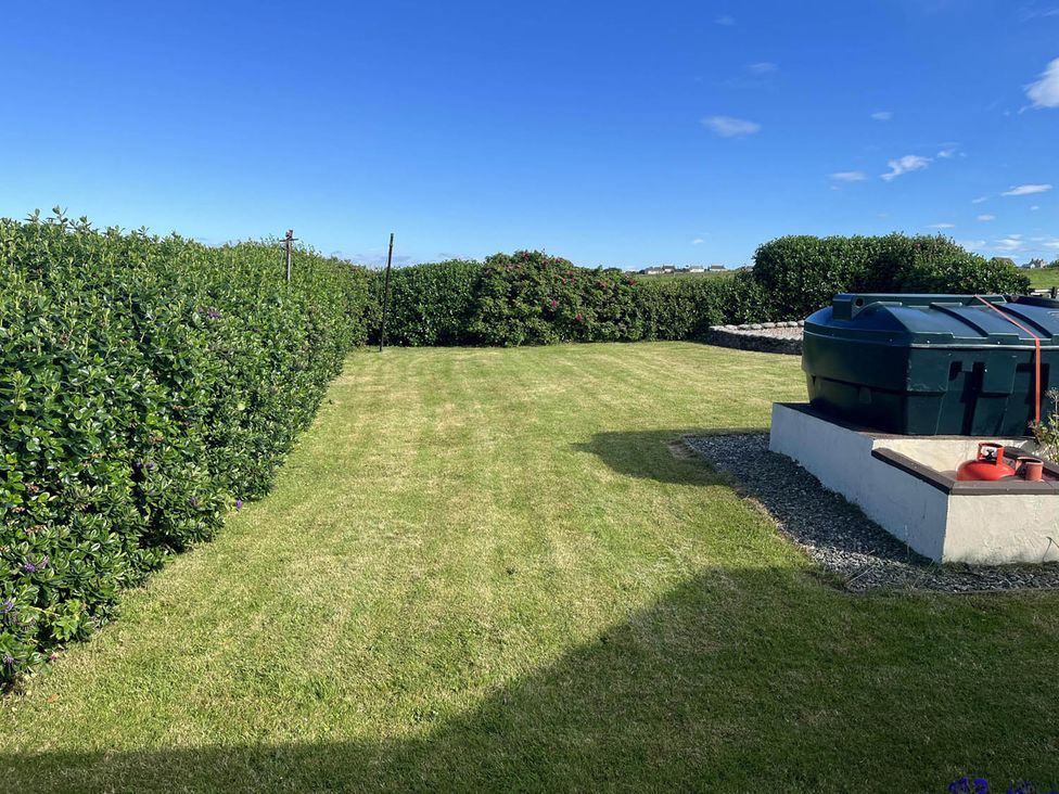 A garden with grass and a storage tank at The Old Barn in Manchester