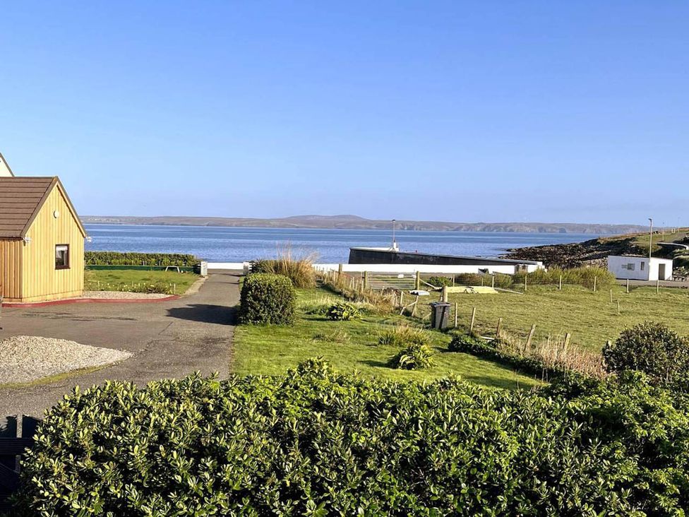 A house with a sea view and green grass at the property location