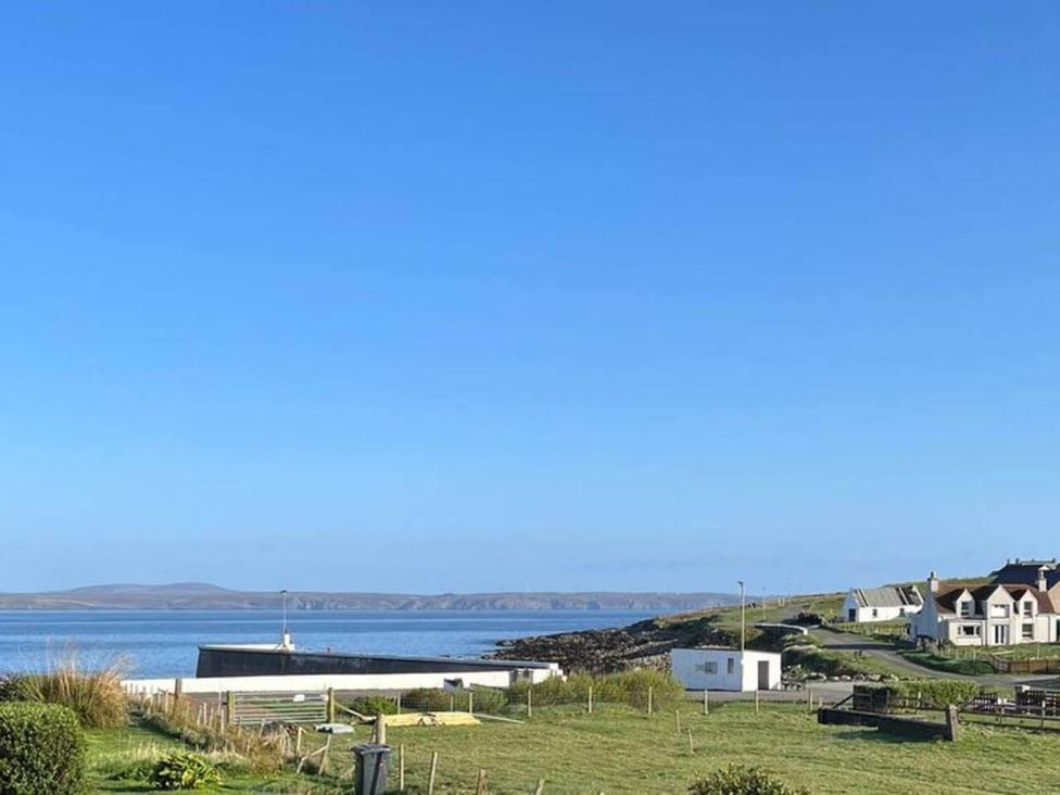 A view of the coast with buildings and grass at an outdoor location