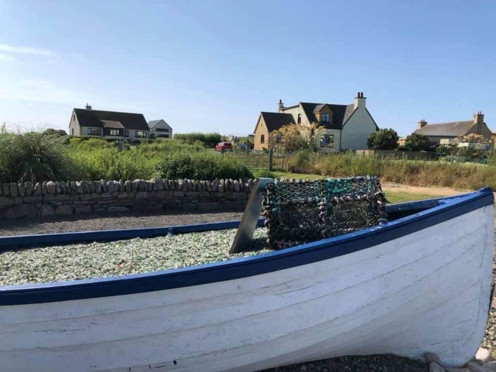 A boat with a net and houses in the background at an outdoor area