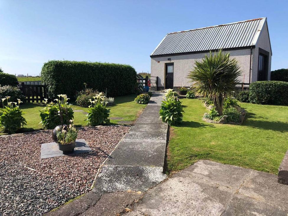 A garden with a pathway leading to a house