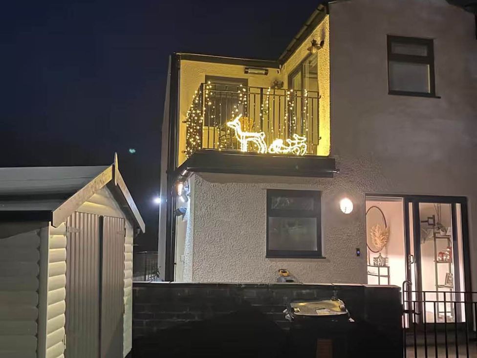A balcony with lights and a shed at a house