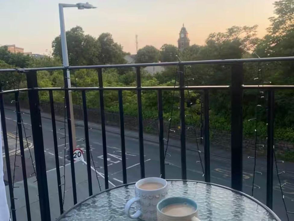 A balcony with mugs and a view of the street at 
