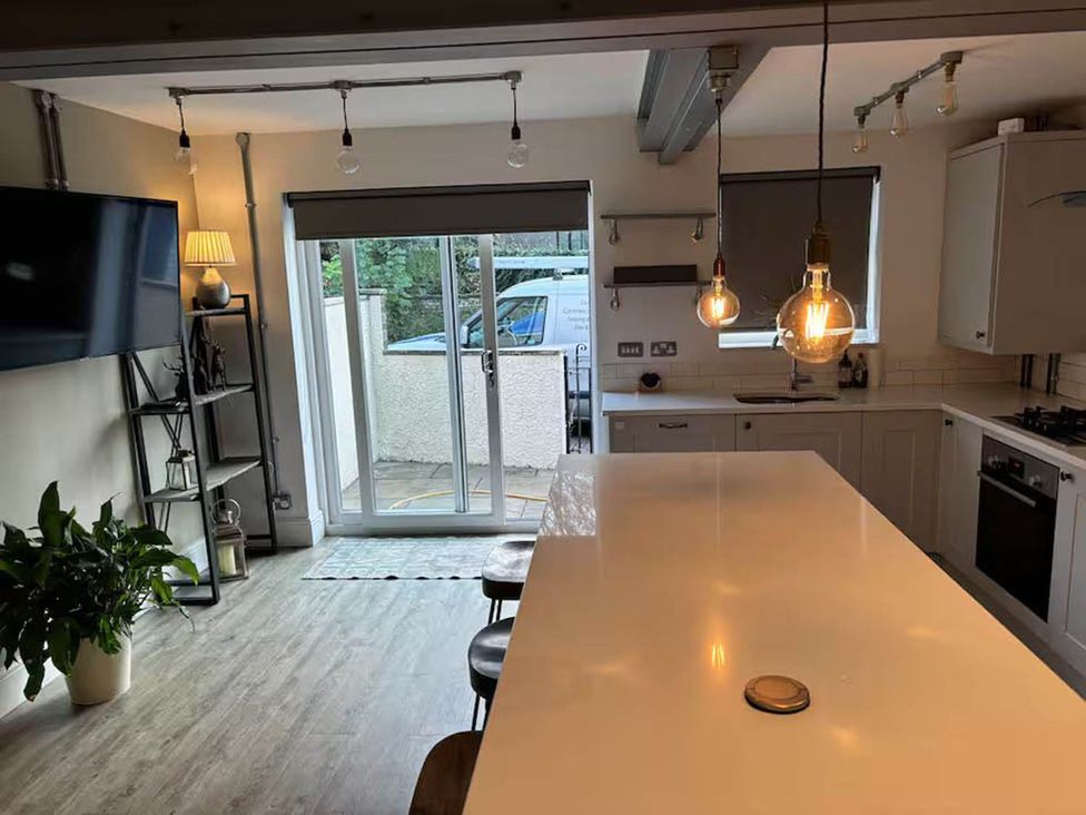 A kitchen with island seating and sliding doors at The Old Barn in Manchester