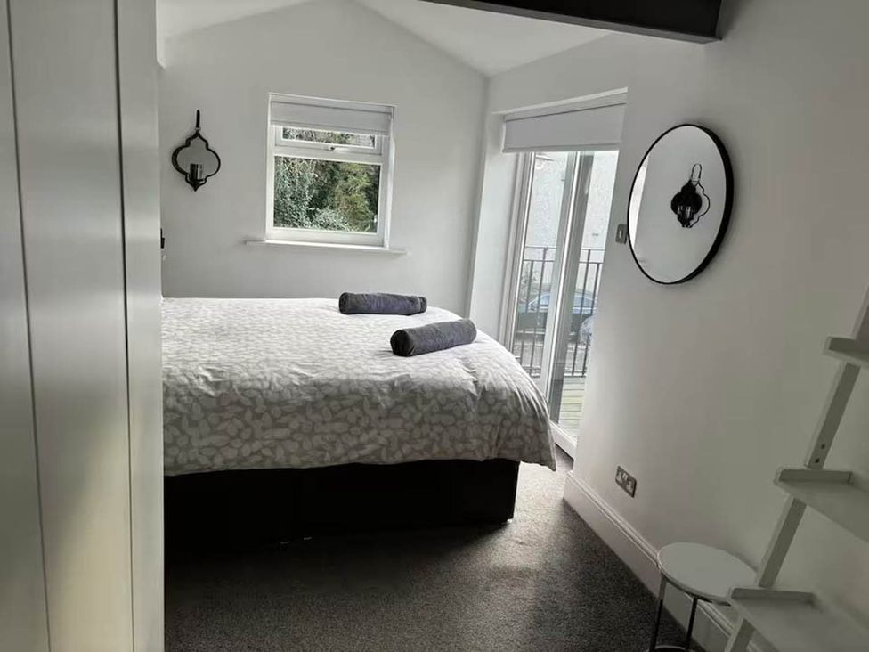 A bedroom with a bed and a mirror at The Old Barn in Manchester