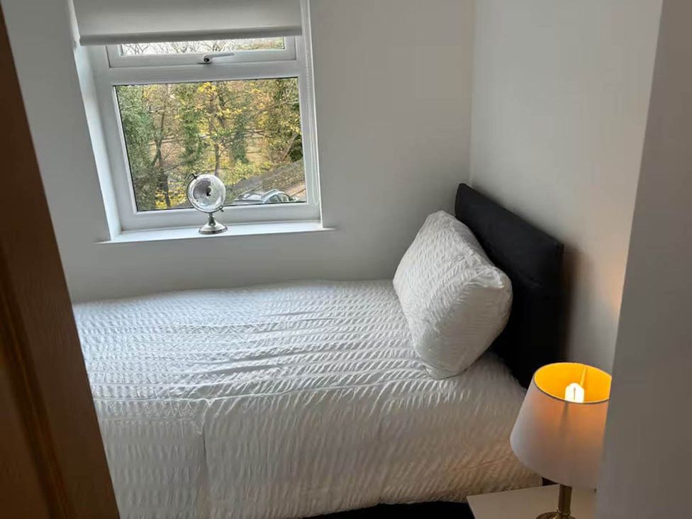 A bedroom with a bed, lamp, and window at the property