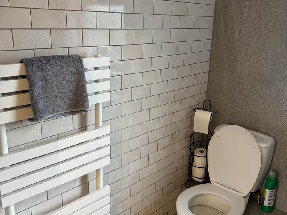 A bathroom with a toilet and towel rack at the property location