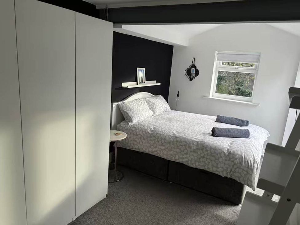 A bedroom with a bed and wardrobe at The Old Barn in Manchester