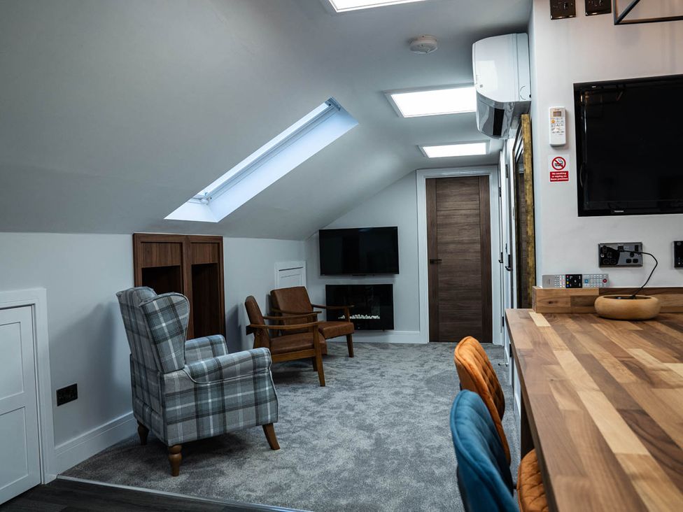 A loft with a television and seating area at The Old Barn in Manchester