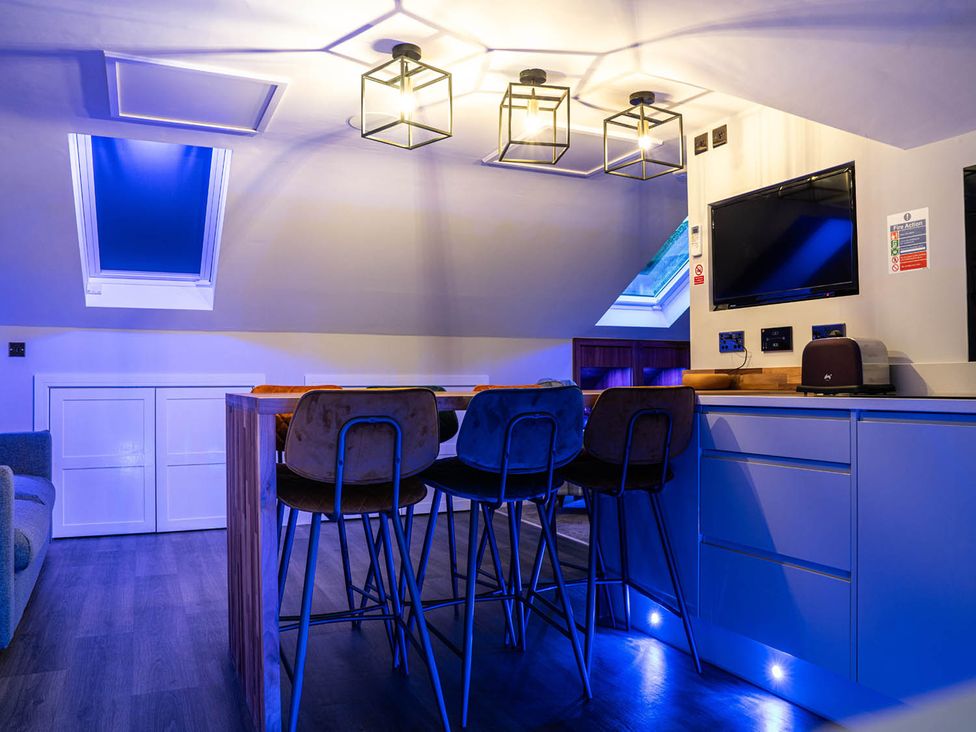 A kitchen with a bar table and stools at the property in location