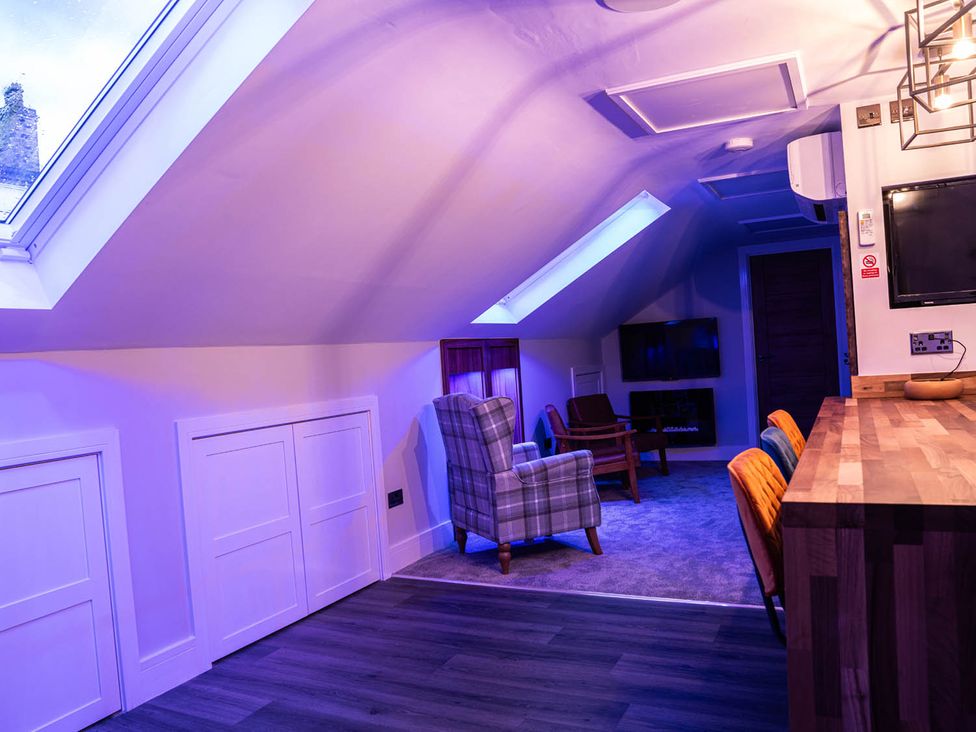 A living room with a skylight, chairs and a table