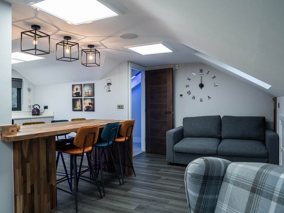 A living room with a bar and stools at the property located in a contemporary setting