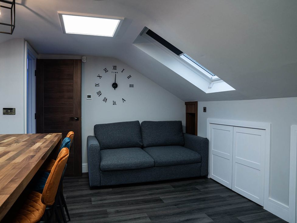 A living room with a sofa and clock at the property