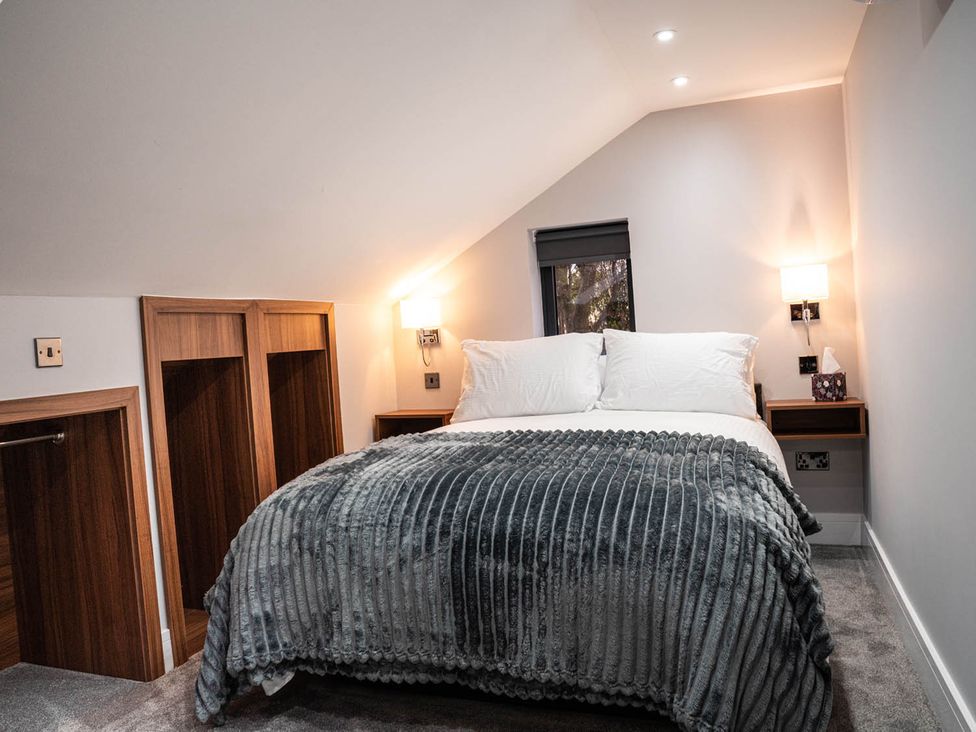 A bedroom with a bed and bedside table at The Old Barn in Manchester