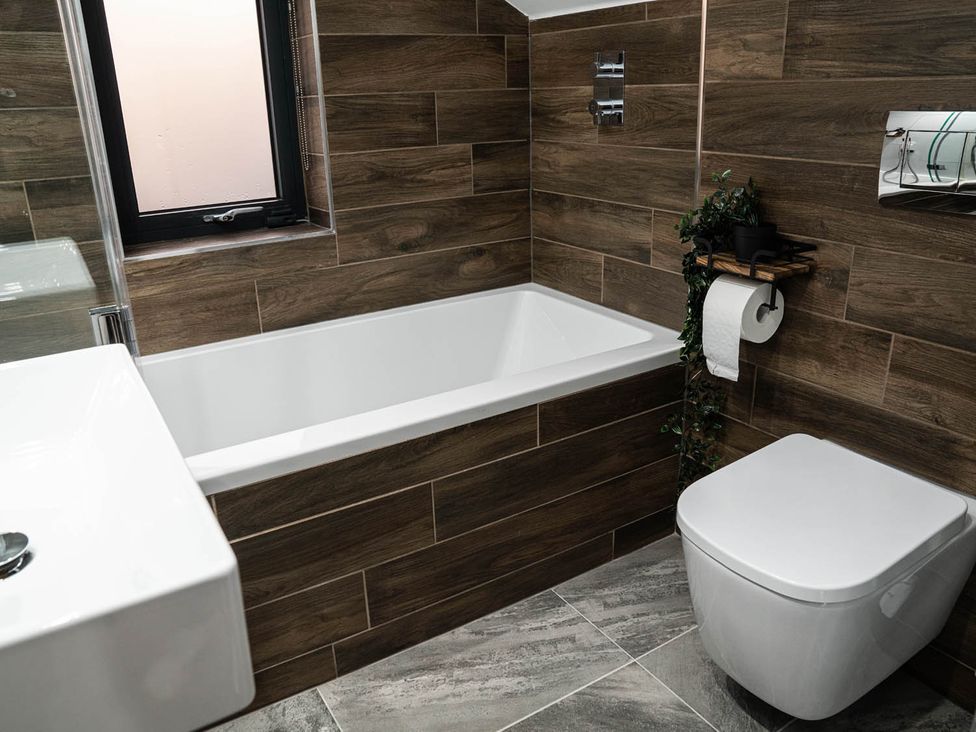 A bathroom with a bathtub and toilet at the property location