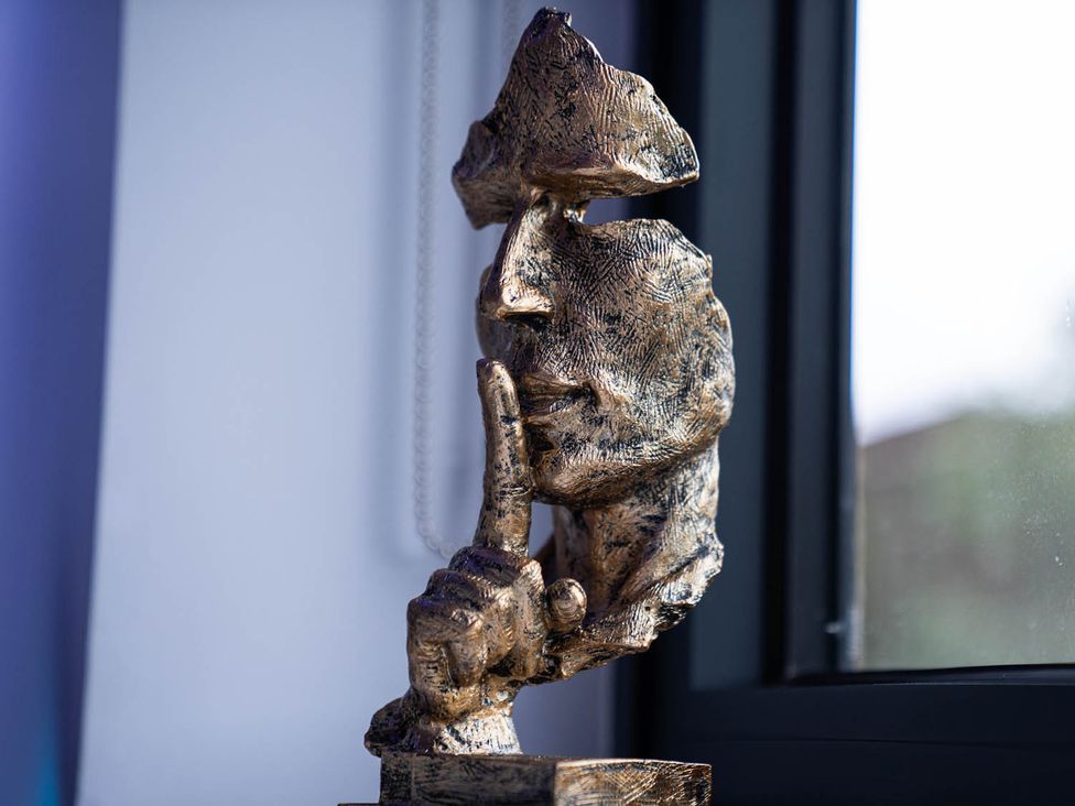 A sculpture of a face and hand at a property in an indoor setting