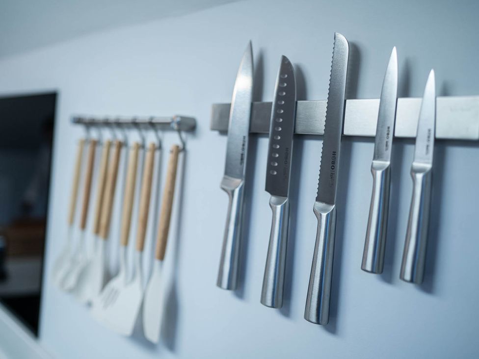A kitchen with knives and cooking utensils on a rack