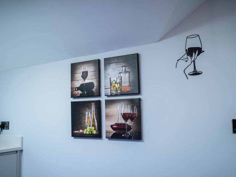 A kitchen wall with framed art of wine and glasses