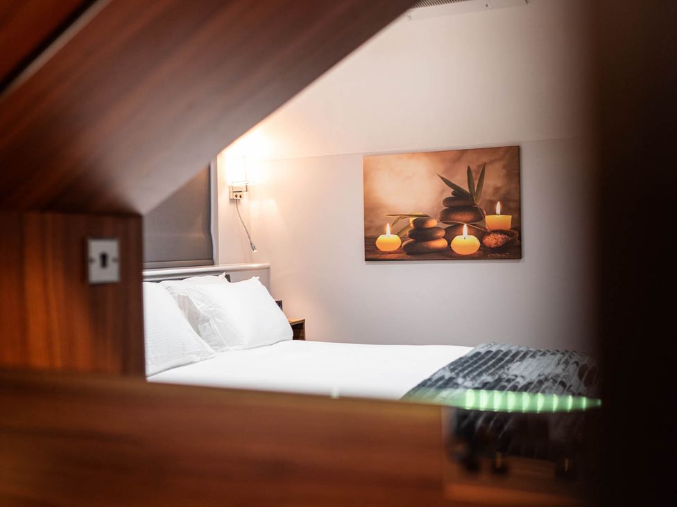 A bedroom with a bed and wall art at The Old Barn in Manchester