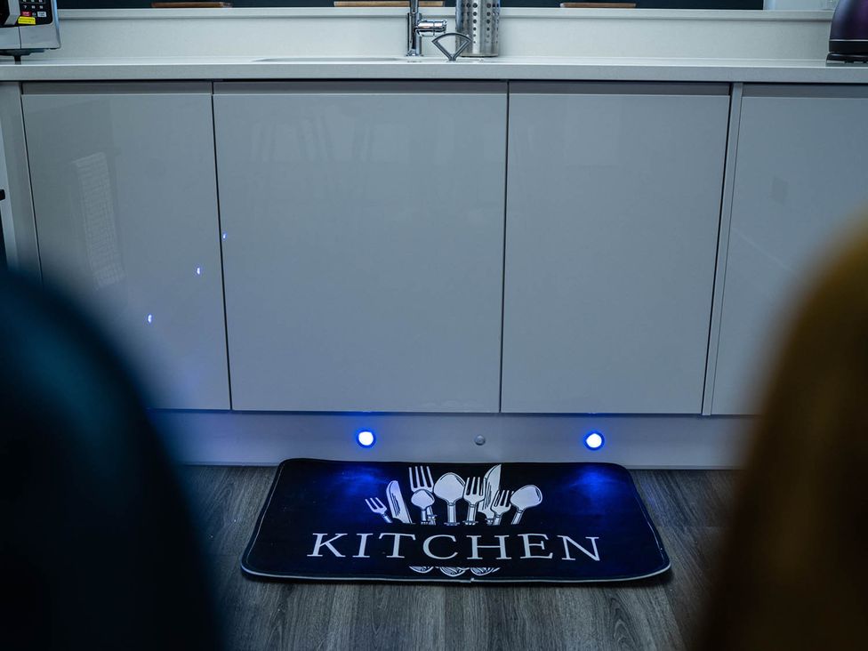 A kitchen cabinet with a sink and a mat at the kitchen