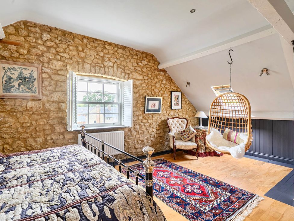 A bedroom with a bed and a hanging chair at Beautiful Pad Near World Heritage Jurassic Coast in Pymore near Bridport