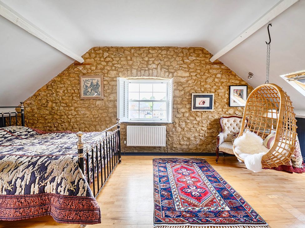 A bedroom with a bed and a hanging chair at Beautiful Pad Near World Heritage Jurassic Coast in Pymore near Bridport