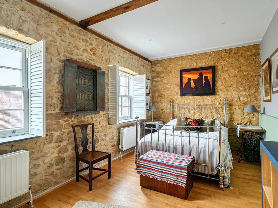A bedroom with a bed and a chair at Beautiful Pad Near World Heritage Jurassic Coast in Pymore near Bridport