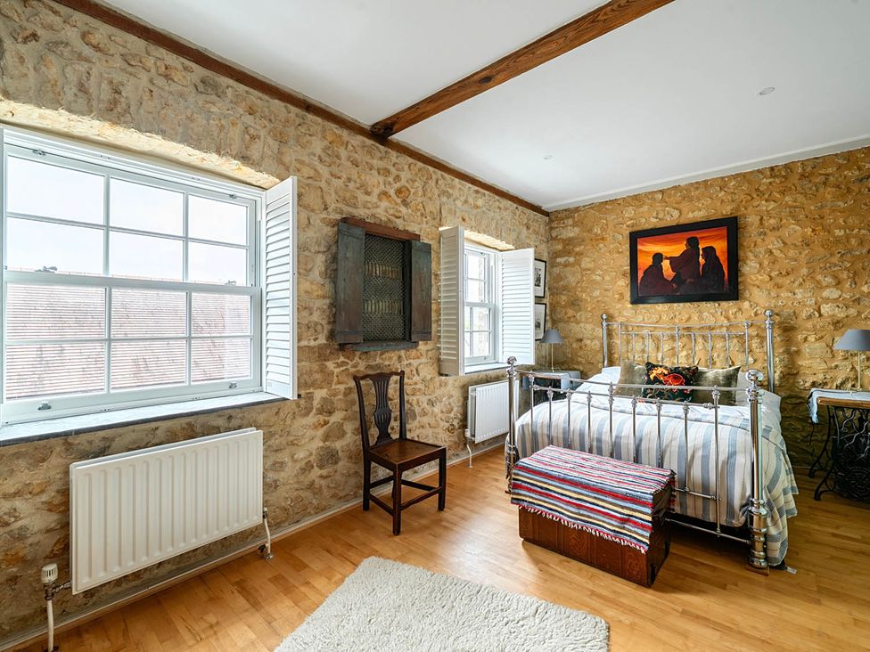 A bedroom with a bed, chair, window, and radiator at Beautiful Pad Near World Heritage Jurassic Coast, Pymore near Bridport