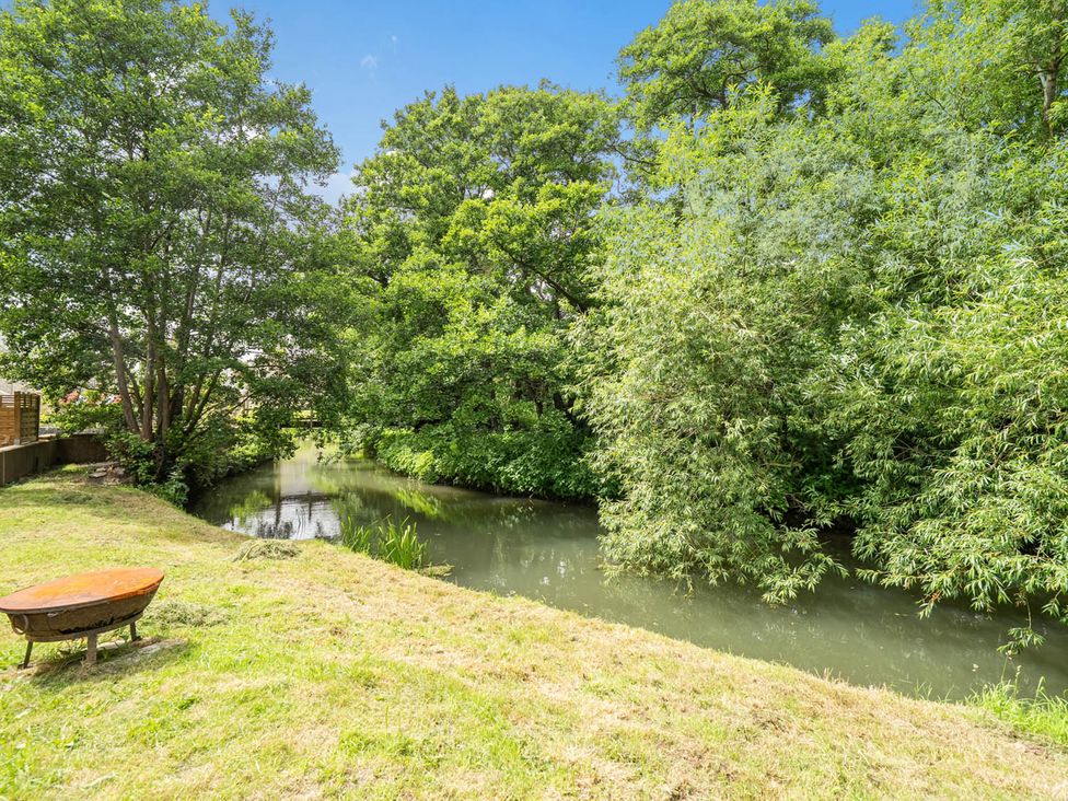 A garden with trees and a stream at Beautiful Pad Near World Heritage Jurassic Coast Pymore near Bridport