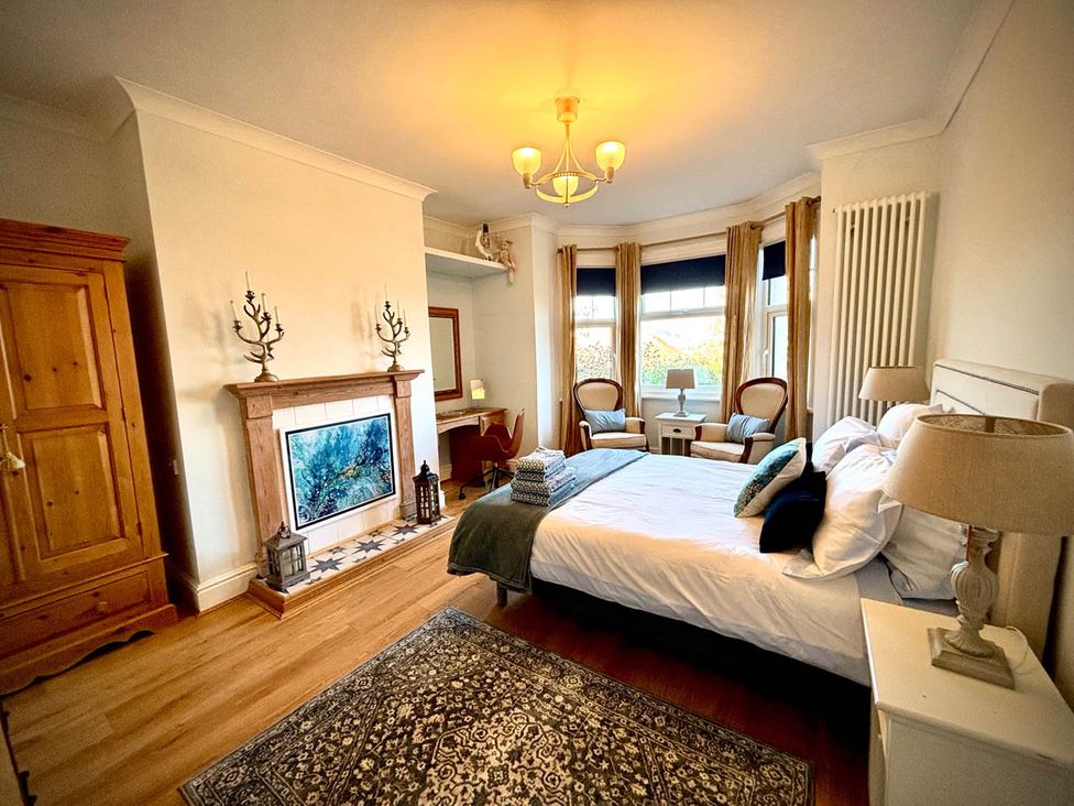 A bedroom with a bed and armchairs at 5 Guests  2 Bedrooms  Free Parking 1min Beach Llandudno