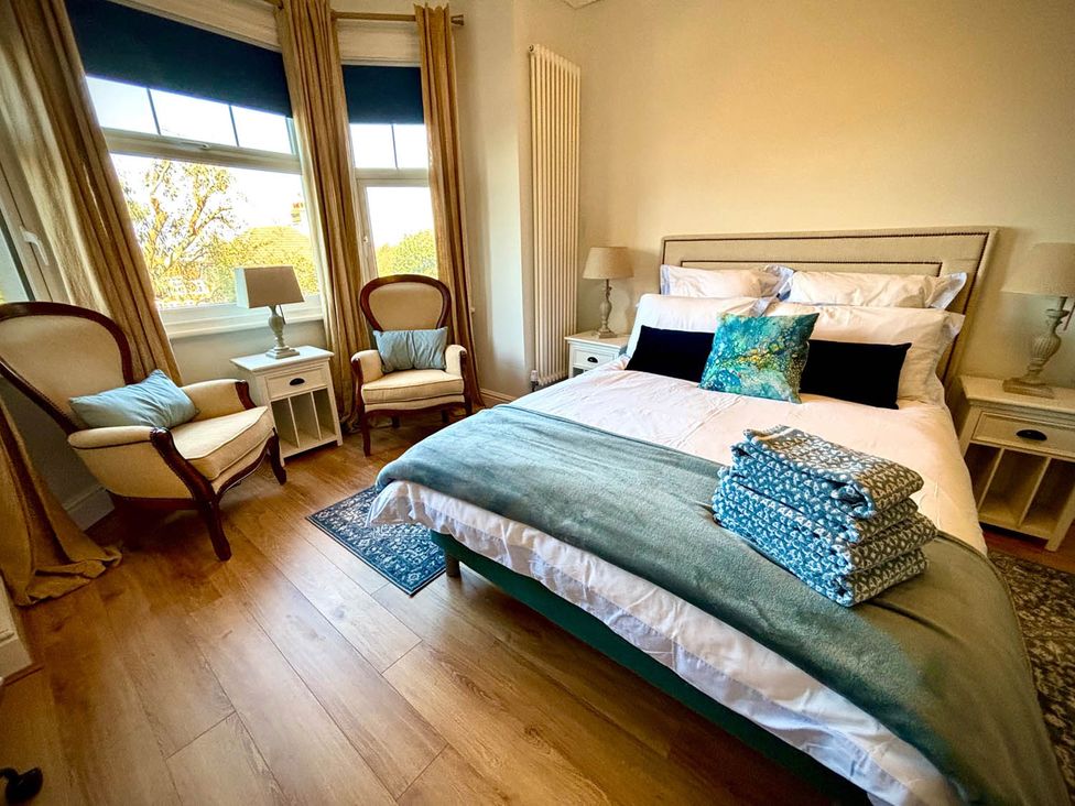 A bedroom with a bed and two chairs at 5 Guests  2 Bedrooms  Free Parking 1min Beach Llandudno