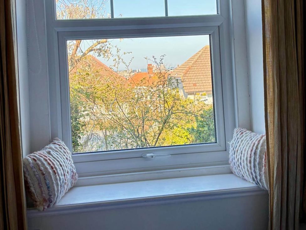 A window with cushions on the sill at The Old Barn in Llandudno