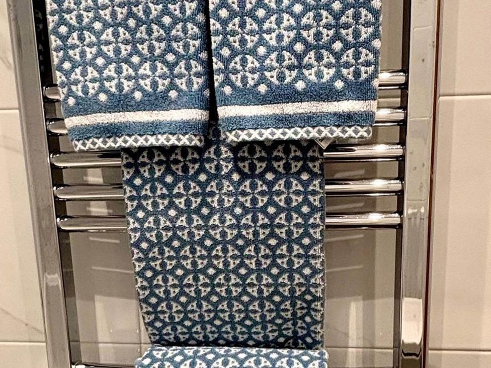 Towels hanging on a chrome towel rack in a bathroom