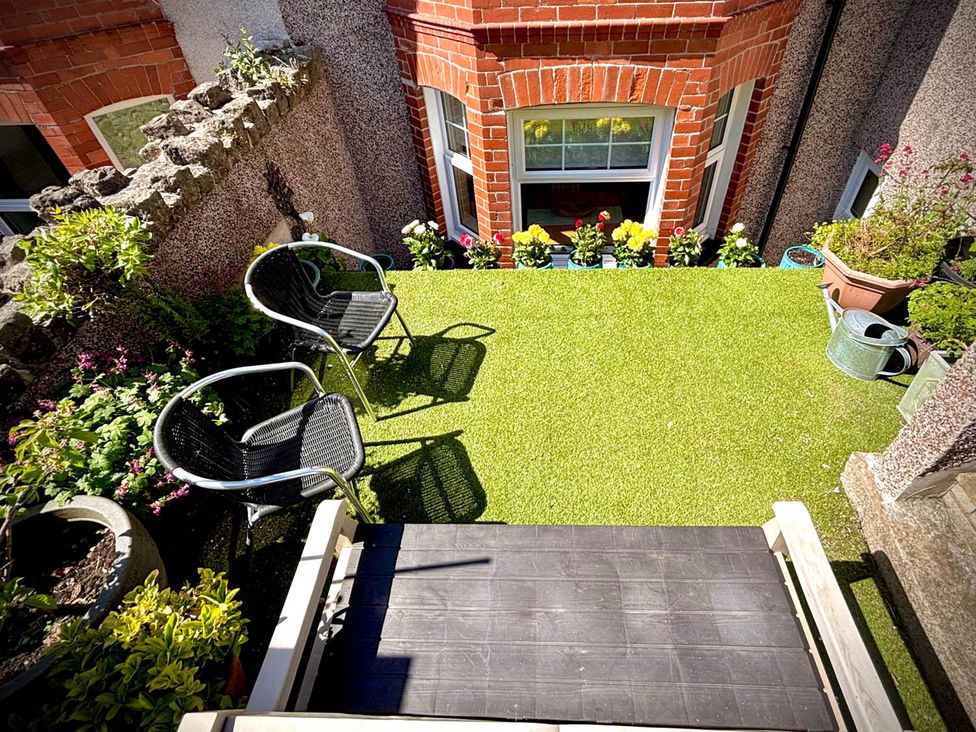 A garden with artificial grass and potted plants at 5 Guests  2 Bedrooms  Free Parking 1min Beach, Llandudno