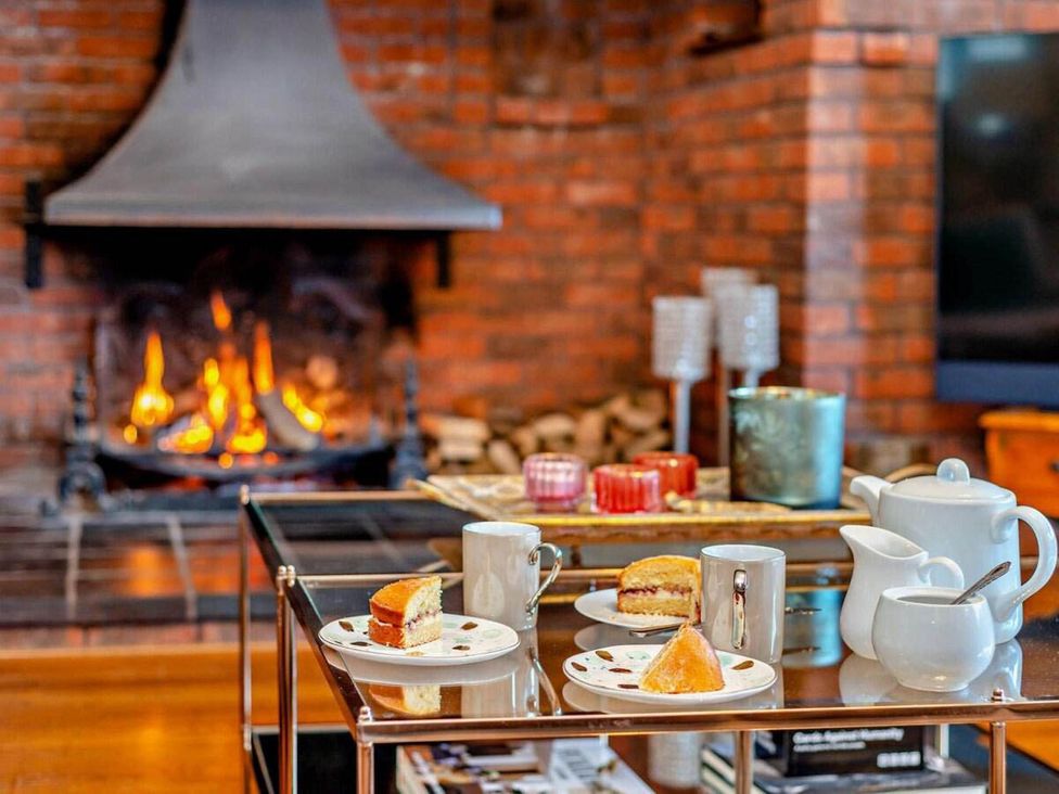 A living room with a fireplace and tea set at Luxurious 5 Bedroom House in Cookham near Marlow