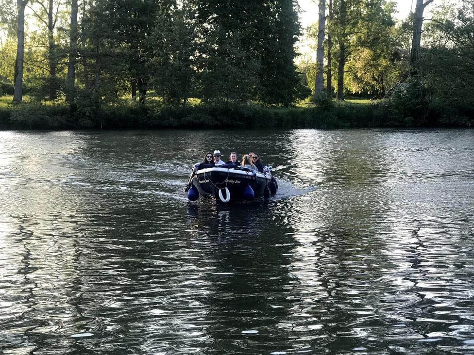 A boat with people on water at Luxurious 5 Bedroom House in Cookham near Marlow