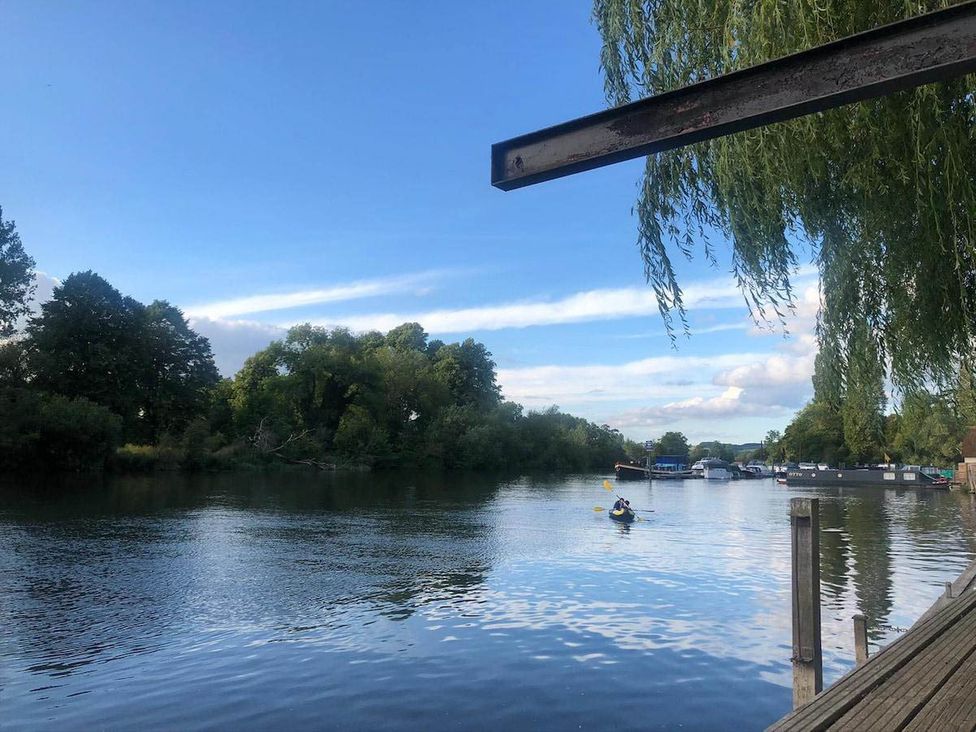 A river with trees and a person kayaking at Luxurious 5 Bedroom House in Cookham near Marlow