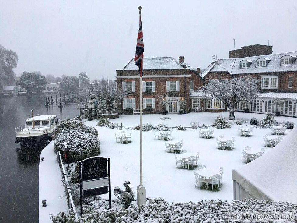 A winter scene with snow-covered outdoor seating at The Compleat Angler in Marlow