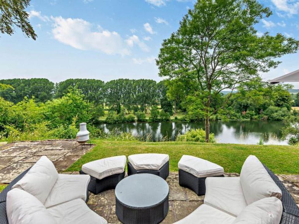 An outdoor patio with seating and a view of the river at Luxurious 5 Bedroom House in Cookham near Marlow