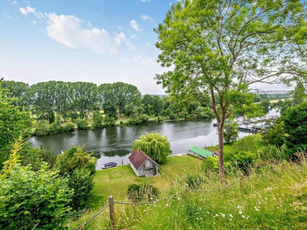 A view of a river with trees and a small house at Luxurious 5 Bedroom House in Cookham near Marlow